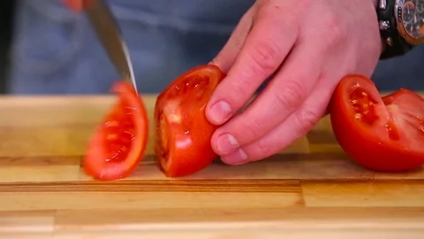 Cook cuts tomatoes close up Stock Footage 74428071