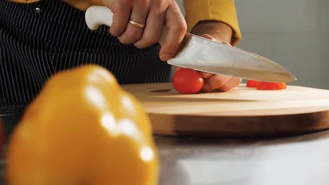 Cook cuts tomatoes with a knife Stock Footage 129956713