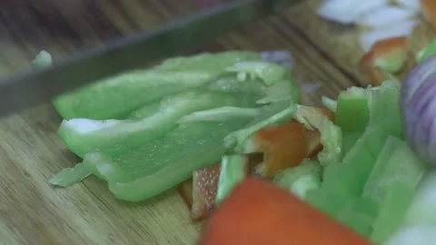 The cook cuts a vegetable pepper with a knife for cooking dinner, on a cutti Vídeos de archivo 221736681