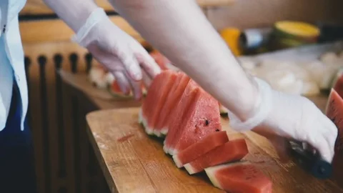 Cook cuts a watermelon with a knife Stock Footage 81543671
