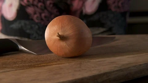 The cook cutting and dice onion on a wooden chopping board. Closeup. Stock Footage 127372575