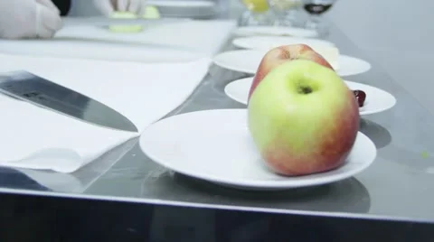 Cook is cutting an apple on the table 스톡 동영상 48395750