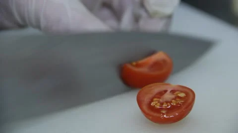 Cook is cutting cherry tomatoes using big kitchen knife 스톡 동영상 48395757