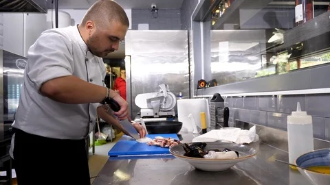 Cook cutting different seafood items on a cutting board Stock Footage 95974887