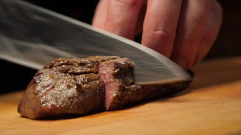 The cook cutting fired beef steak with a knife Stock Footage 152717101