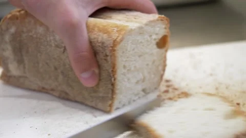 Cook cutting fresh bread into slices for traditional bruschetta Stock Footage 336793346