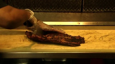 Cook cutting a hot rack of BBQ ribs Stock-Footage 78252986