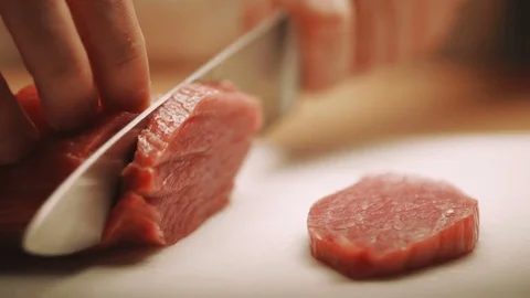 Cook cutting up an meat with a knife. Hands cutting fresh meat Close-Up Stock Footage 73273937