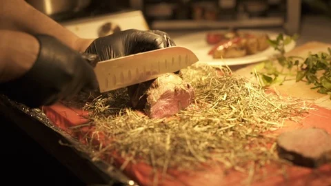 Cook is cutting meat preparing it for a meal Stock Footage 119275811