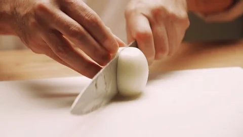 Cook cutting up an onion with a knife Stock Footage 73274417