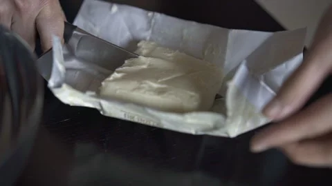 Cook cutting off a piece of butter for baking Stock Footage 263185693