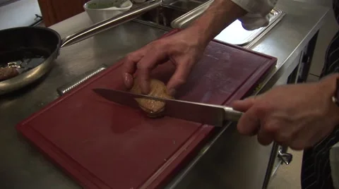 Cook is cutting a pork filet into small slices Stock Footage 43078394