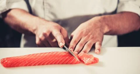 Cook cutting salmon Stock Photos