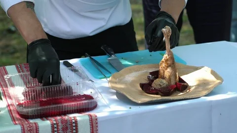 Cook decorates chicken dish with beet on the food festival on the open air. Видео 108409464