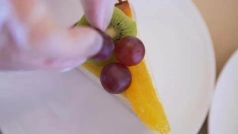 The cook decorates the dessert with fruit Stock Footage 87755956
