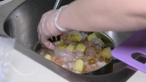 Cook dinner at home. raw potatoes with chicken pieces in a pot 動画素材 99821877