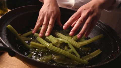 A cook dips an edible burdock in ice water to cool. Stock Footage 119189813