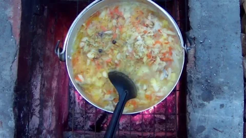 Cook the dish on an open fire in a barbecue Stock Footage 74392607
