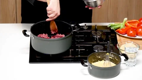 The cook distributes the minced meat over the bottom of the saucepan Vídeo Stock 311968185