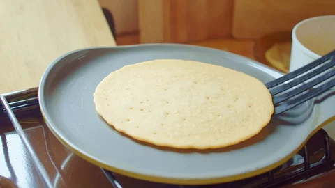 Cook flips delicious bake pancake with spatula in frying pan. Close up. Slowmo. Stock Footage 127966858