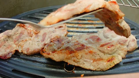 Cook flips the meat on the grill with spatula Stock Footage 267440369