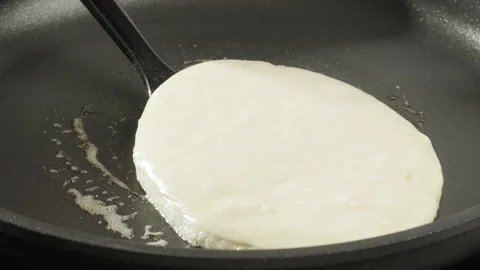 The cook flips the pancake on the pan with a spatula. Baking pancakes at home. Stock Footage 264498511
