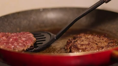 Cook flips round burger patty. Chef turns cutlet on frying pan with spatula Stock Footage 312514185