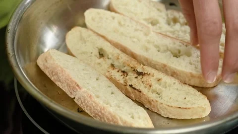 The cook flips slices of bread to the other side into the pan. Stock Footage 247895761