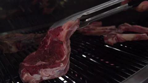 The cook flips a steak on the grill Video stock 221363227