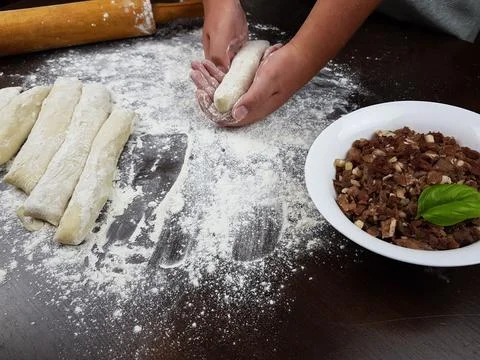 The cook forms the dough on a dark background. there is a rolling pin on the  Stock Photos