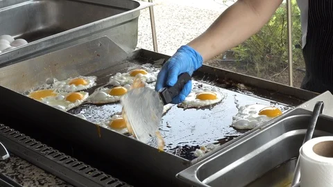 The cook fry eggs for breakfast. The concept of relaxation, vacation, travel  Stock Footage 96042832