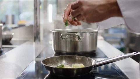 Cook frying pasta in a pan on an electronical stove. Stockbeeldmateriaal 119033191