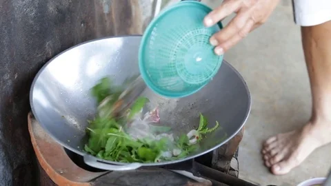 Cook is frying squid with basil Stock Footage 81636924
