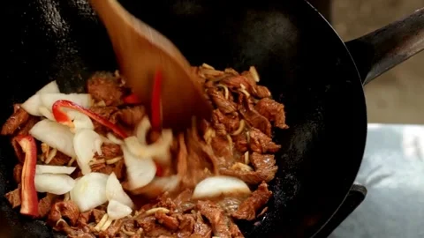Cook frying thin slices of bacon on a hot pan and stirring them with a spatula. 스톡 동영상 334643519