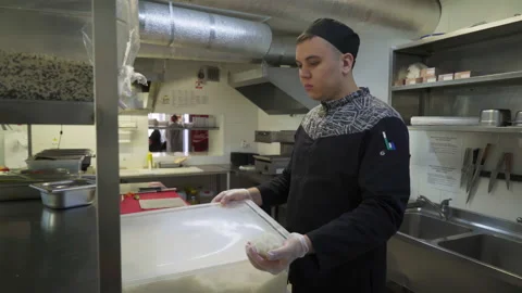A cook is getting the prepared fresh ingredients from the big plastic container Stock Footage 158284249