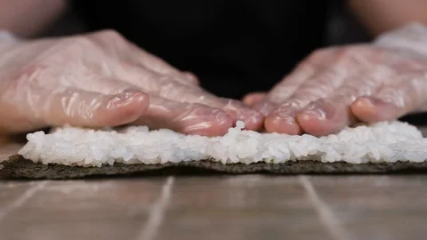 A cook in gloves in the kitchen crumples rice for rolls Stock Footage 124211601