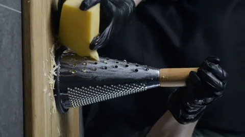 Cook grates cheese on a grater. Vertical video Stock Footage 248817196
