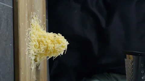 Cook grates cheese on a grater. Vertical video Stock Footage 248817200