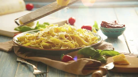 A cook grates the cheese upon the plate of Italian pasta Stock-Footage 61787317
