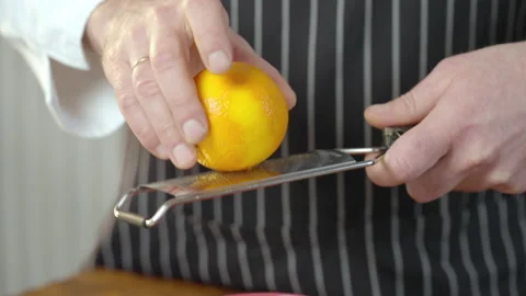 The cook grates the orange peel. Doing Spice From Orange Peel. Slow motion video Stock Footage 234317363