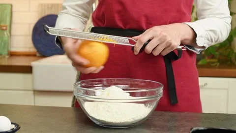 The cook grates the orange peel. Stock Footage 247895599