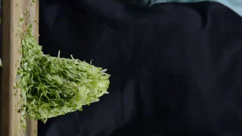 Cook grates zucchini on a grater Stock Footage 248775761