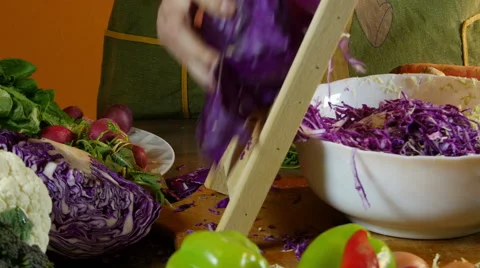 Cook grating cabbage for salad with grater in kitchen, close up, dolly Stock Footage 60580096