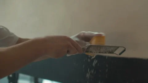 Cook is grating cheese that falls on pizza Stock Footage 120803176