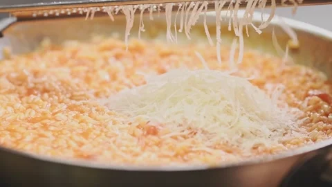 The cook grating parmesan cheese on tomato risotto. Stock Footage 159399531