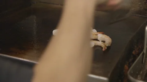 Cook grilling shrimp on flat top grill Vidéo 104880934