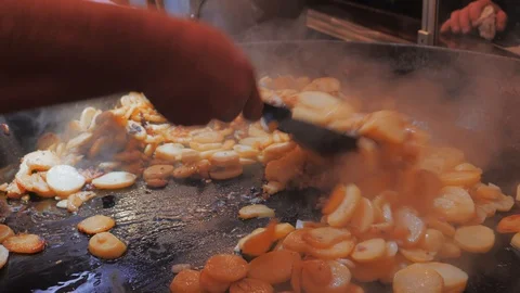 Cook hand mixing fried potatoes in large saucepan. Unhealth food 動画素材 97726338