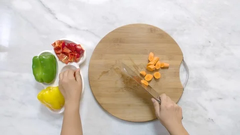 Cook hands cut carrots on a black board on a table with a large cook knife Stock-Footage 122235239