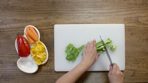 Cook hands cut pepper and carrots on a white board with a large cook knife Stock Footage 122765598