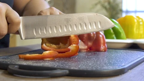 Cook hands cut pepper on a black board on a table with a large cook knife Stock Footage 122148040